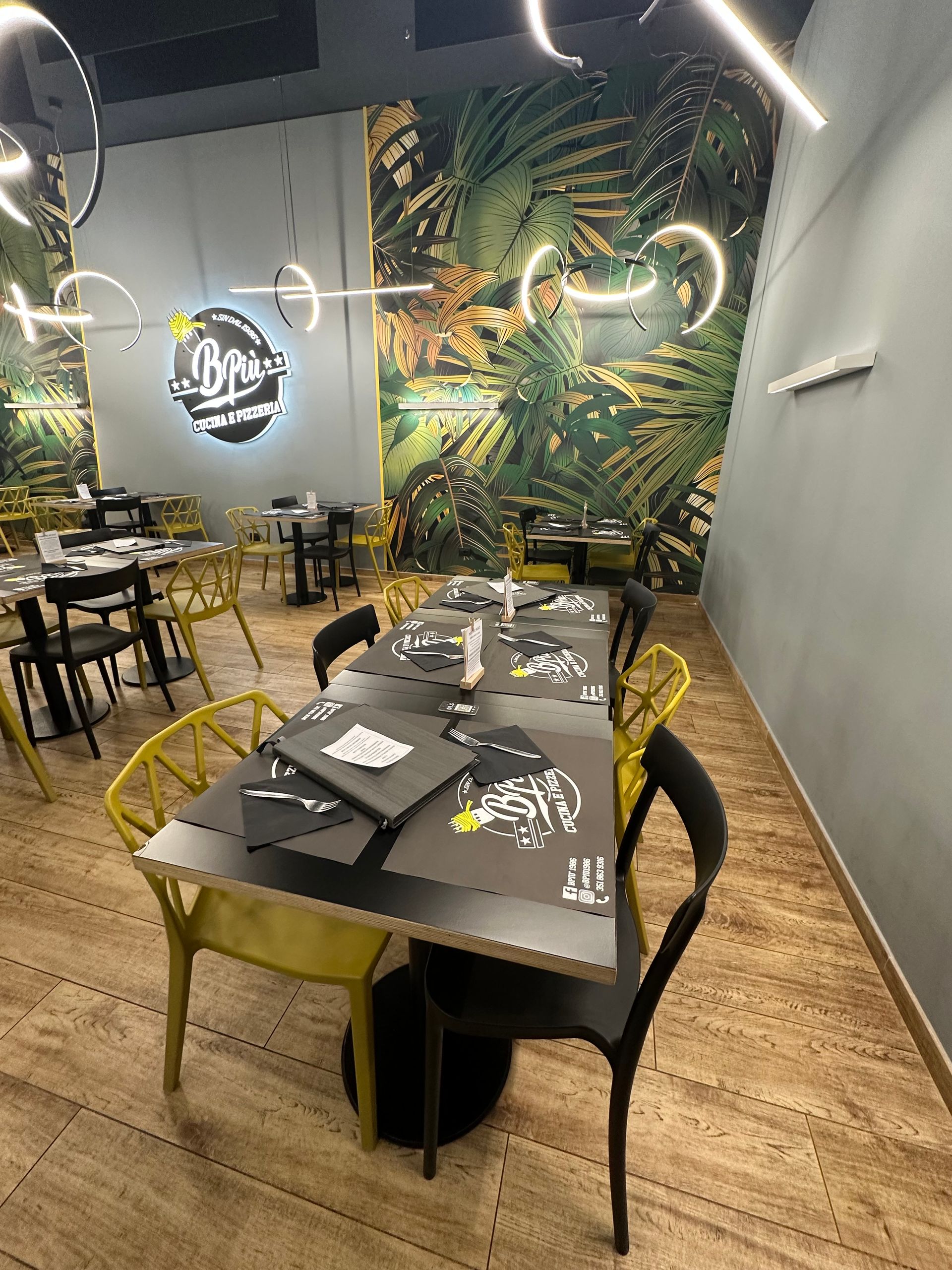 Un ristorante con tavoli e sedie e un'insegna al neon sul muro.