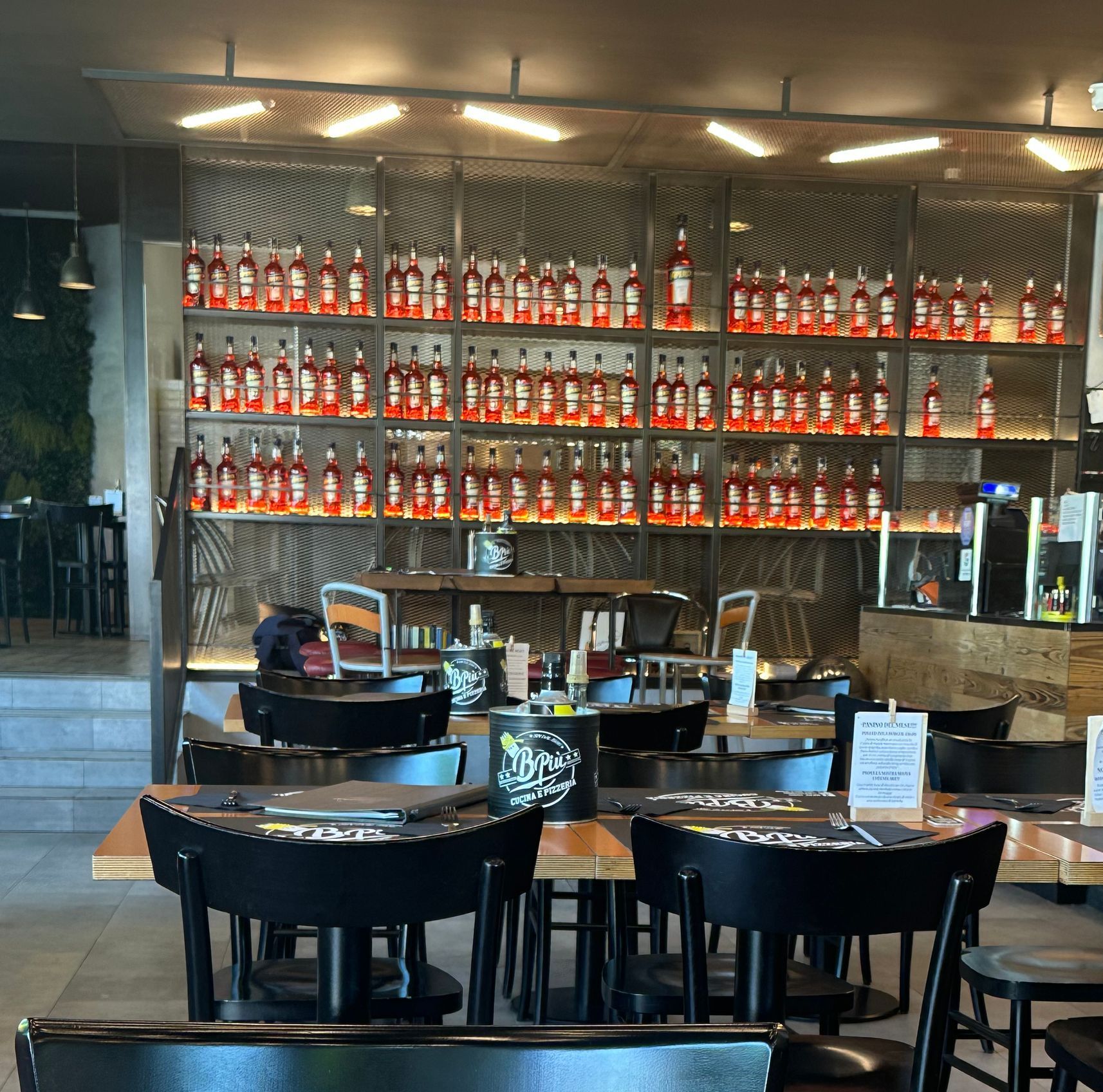 Un ristorante con tante bottiglie sugli scaffali, sui tavoli e sulle sedie