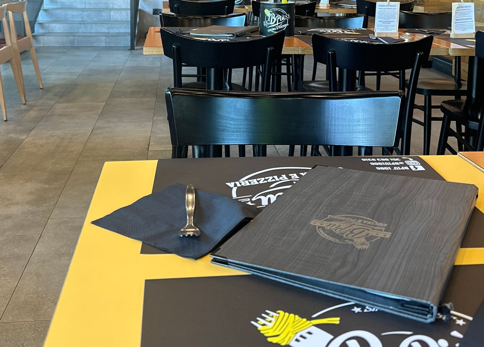 Un ristorante con tavoli e sedie e un menu sul tavolo