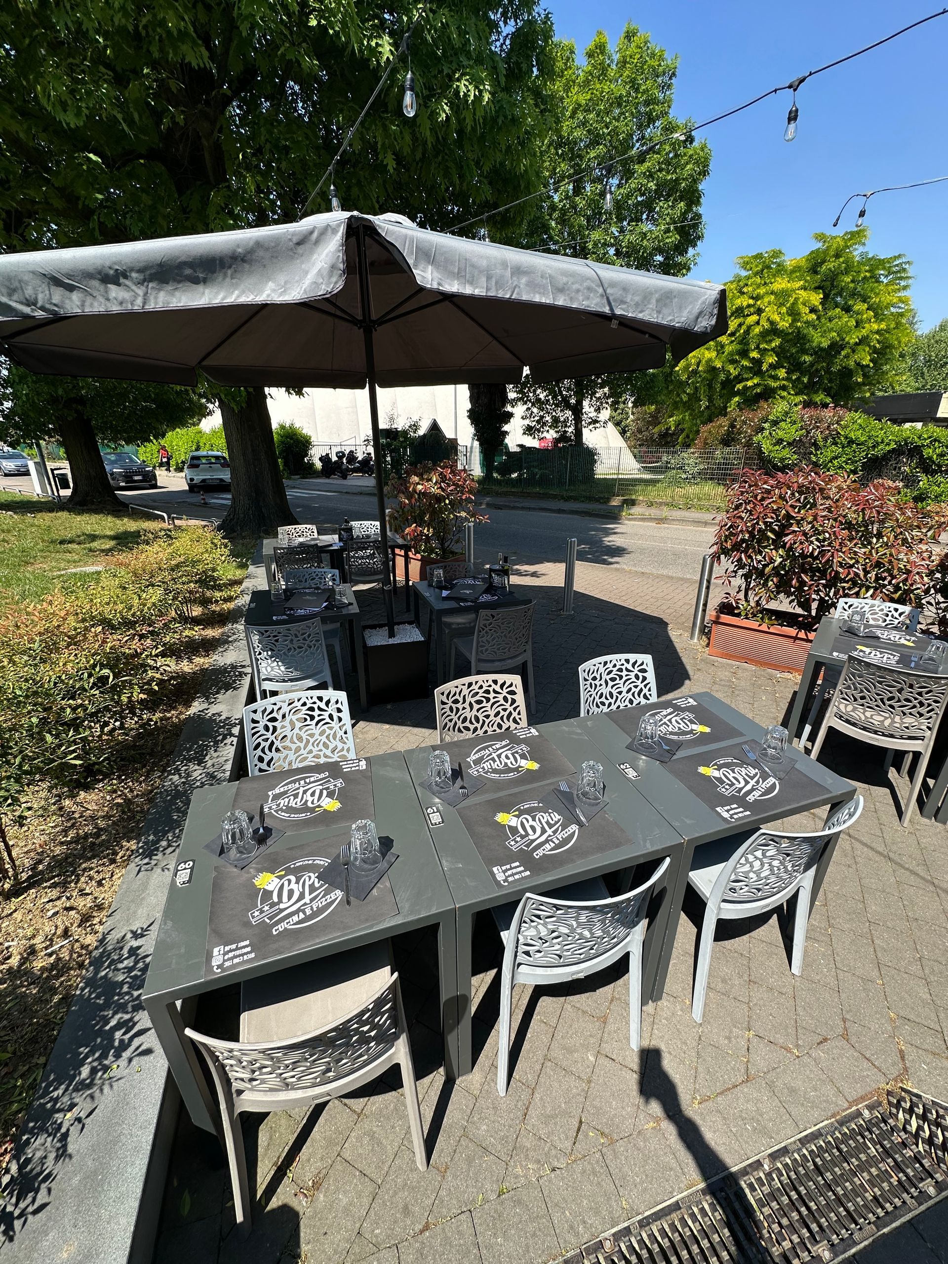 Un patio con tavoli e sedie sotto un ombrellone.