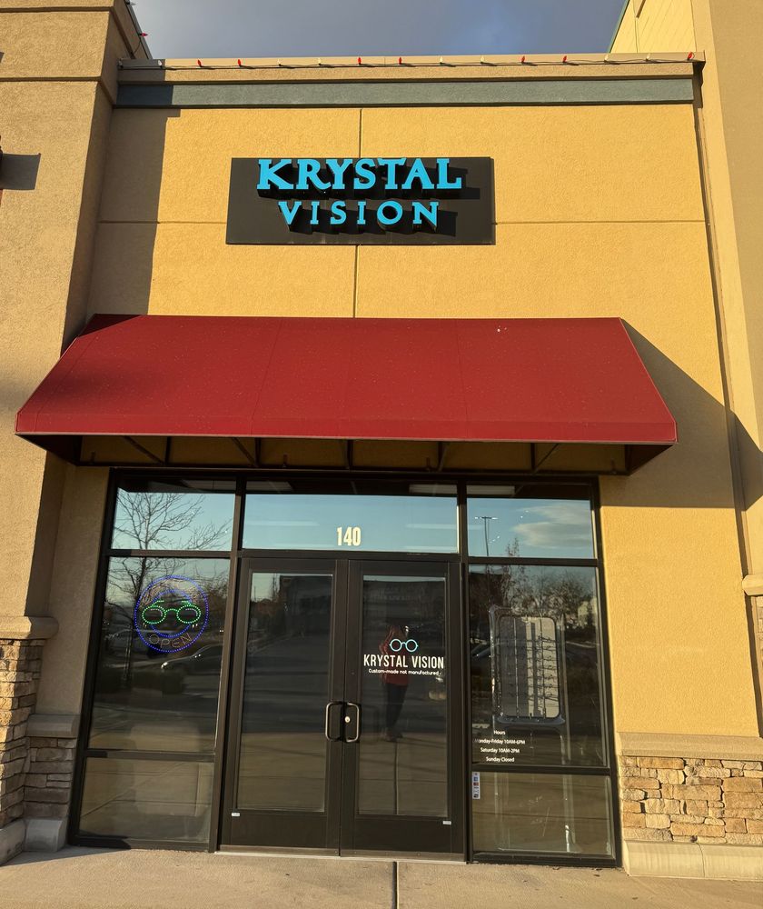 Person trying on eyeglass frames in an optical store display