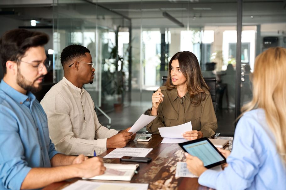A group of people are sitting around a table having a meeting.