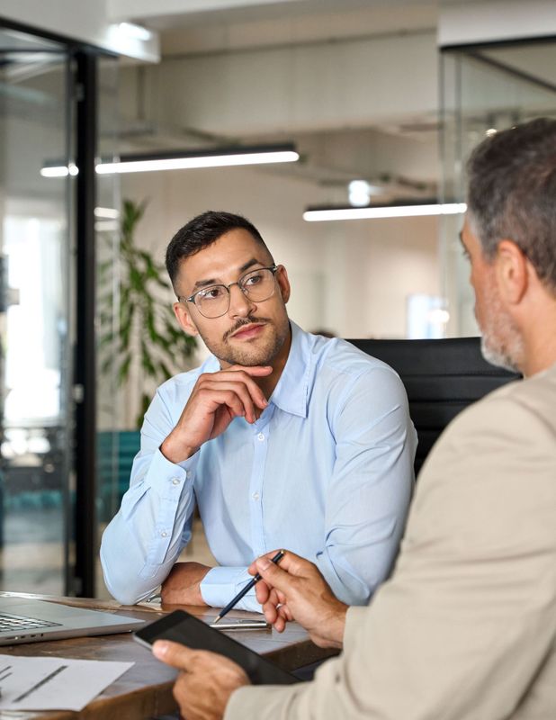 Two men are sitting at a table having a conversation.