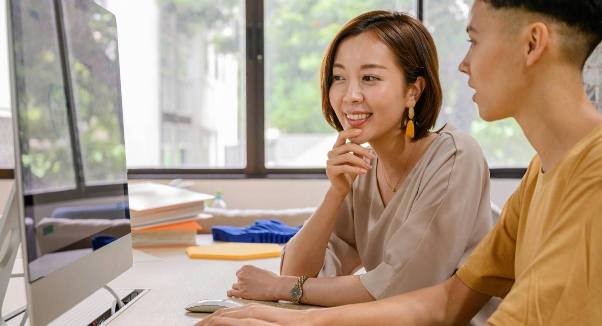 Two people looking at a screen with interest