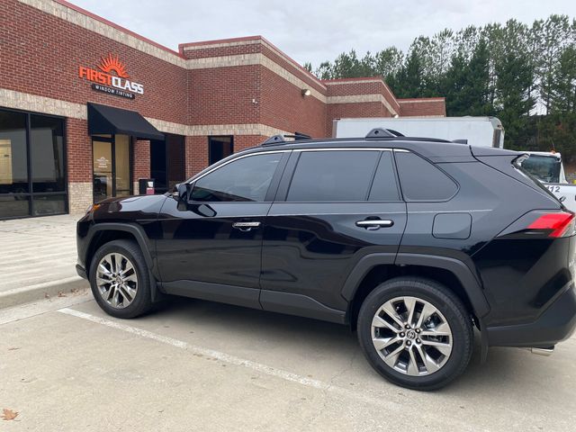 A black suv is parked in a parking lot in front of a brick building.