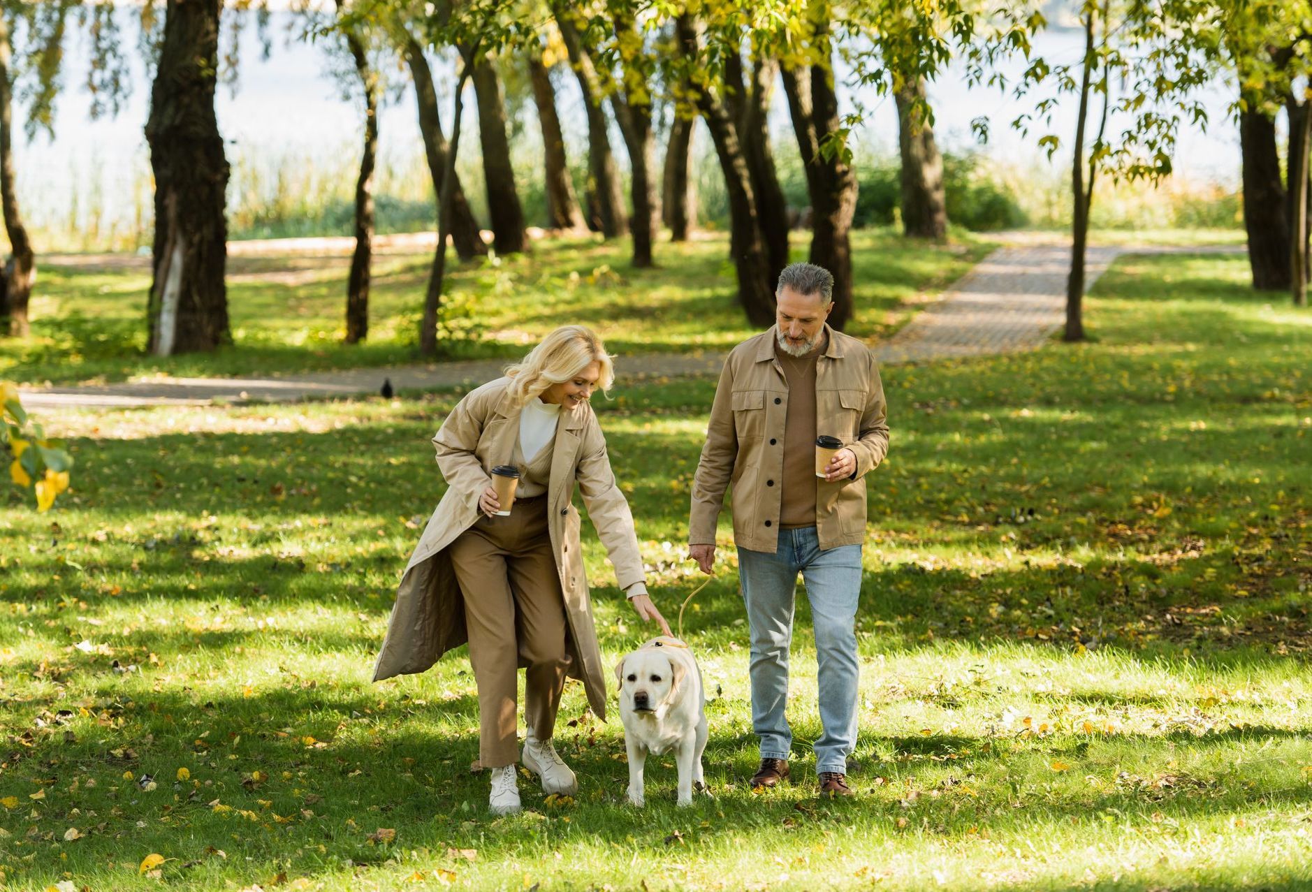 middle aged couple in the park with their dog