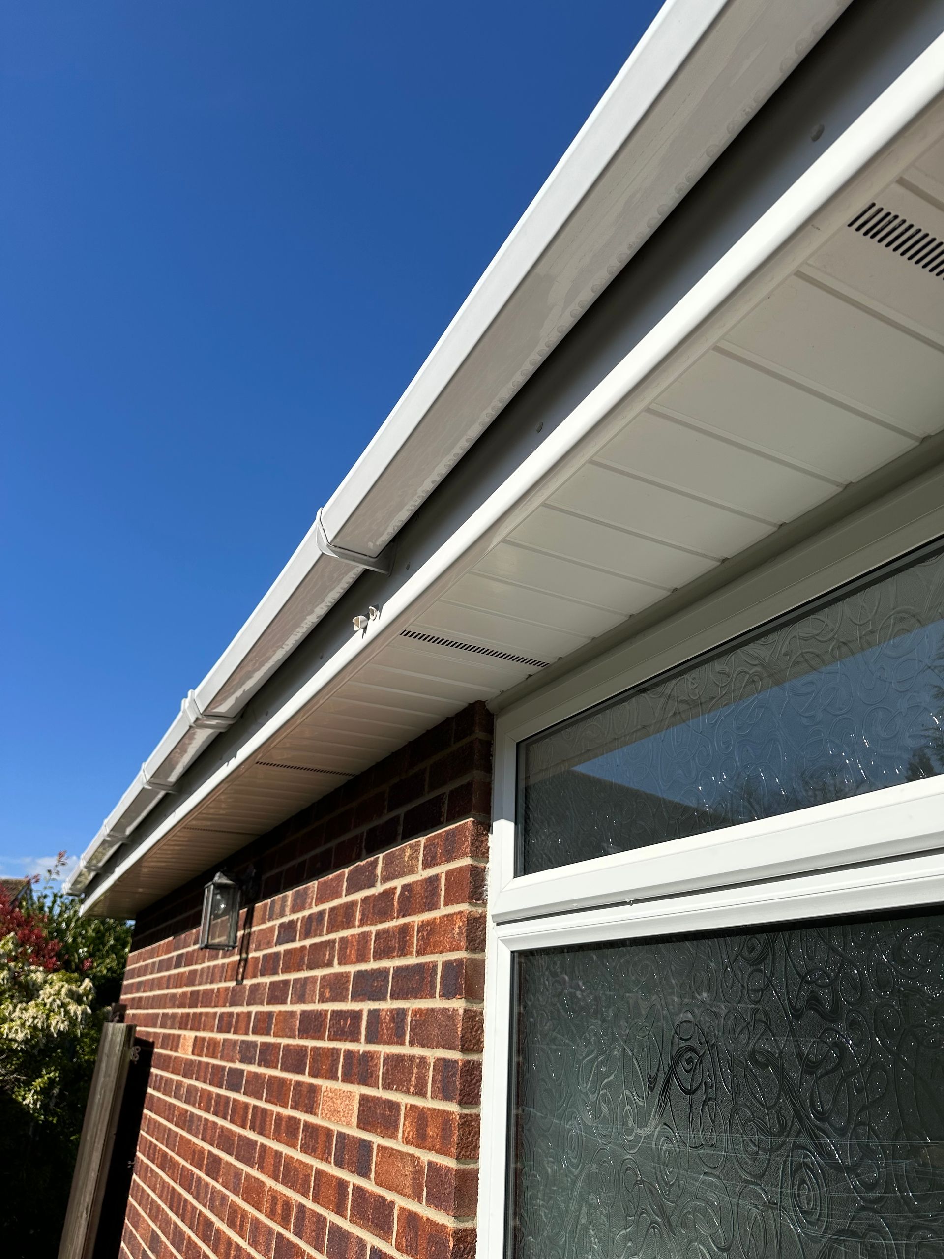 A modern house in the middle of a forest surrounded by trees.