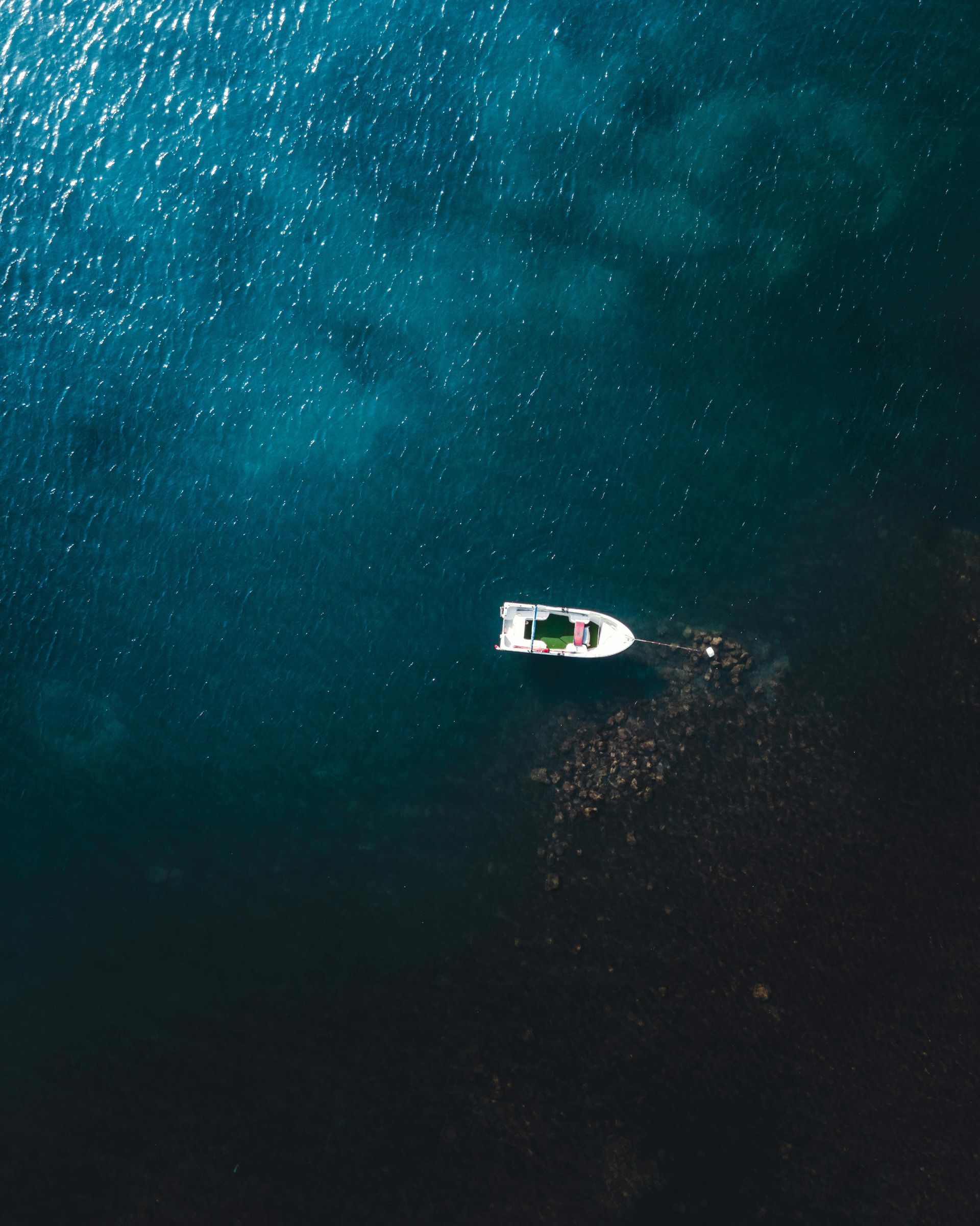 An aerial view of a boat in the middle of the ocean.