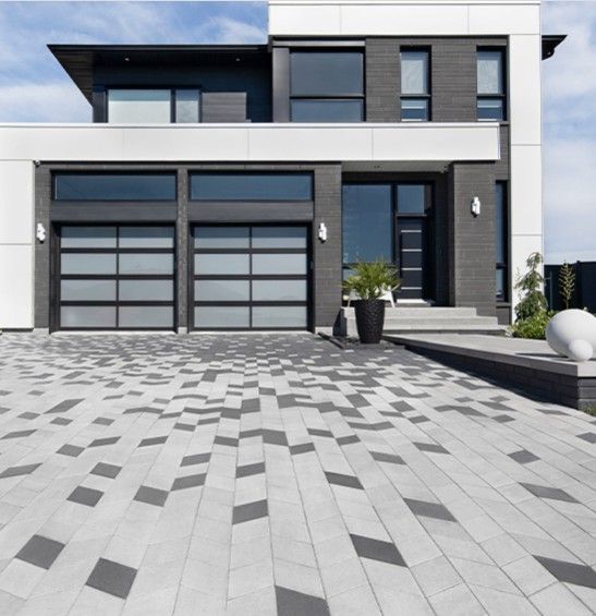 Modern Driveway Design with geometric design pavers in front of large modern two story home