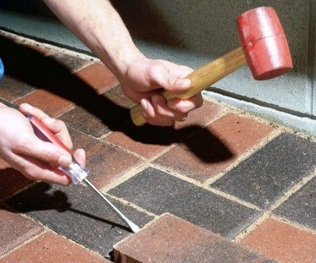 dangerous trip hazards located on Damaged Driveway with uneven Pavers