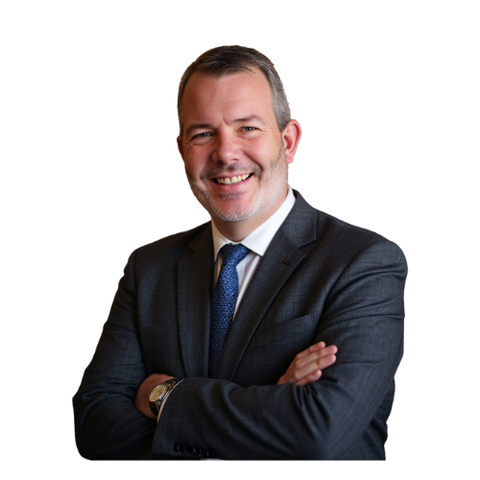 Man in suit, smiling with arms crossed. Dark suit, blue patterned tie, watch visible.