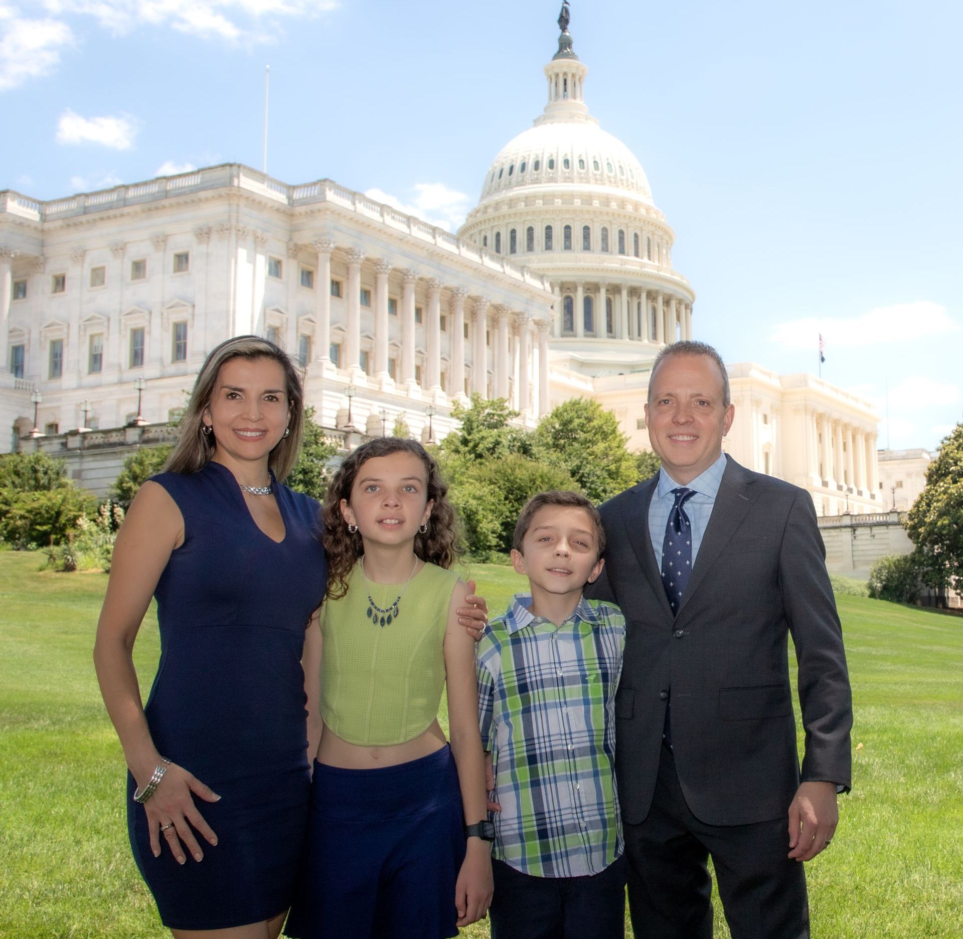 A family poses in front of the capitol building