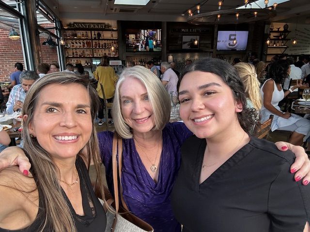Three women are posing for a picture together in a restaurant.
