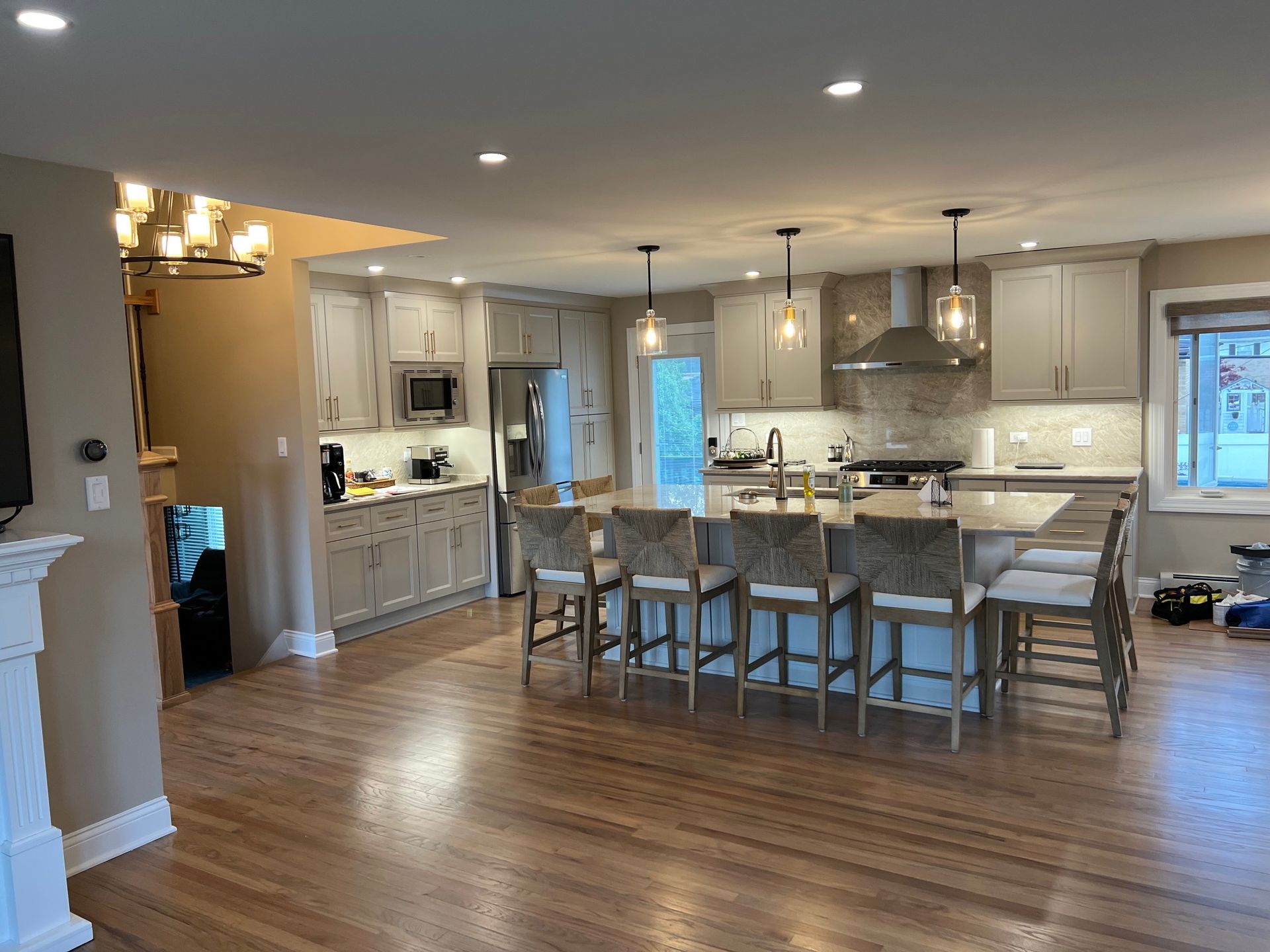 Spacious kitchen with a large island, light cabinets, and hardwood floors.