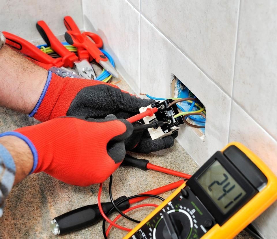 An electrician is working on an electrical outlet and a digital multimeter reads 241