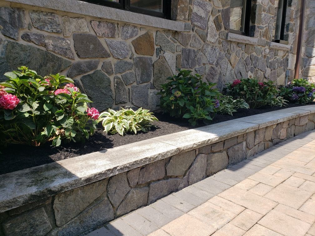 A stump grinder is cutting a tree stump in the grass.