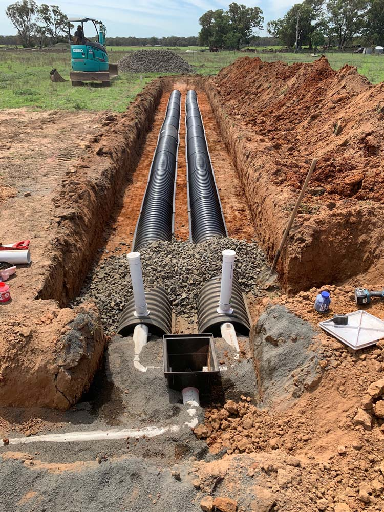 Trench With Black Pipes and Gravel for a Septic System — Zac Rennick Plumbing in Geurie, NSW
