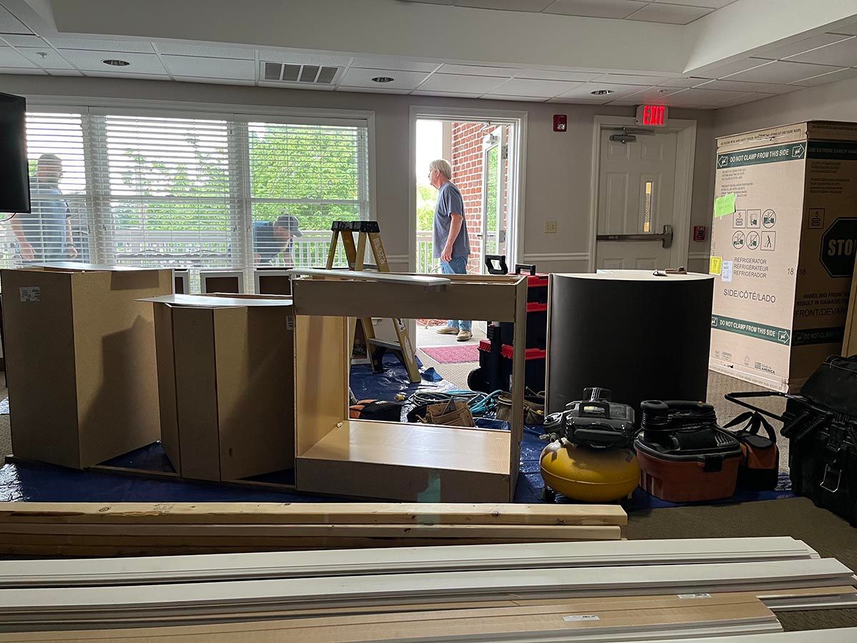 A man is standing in a room filled with boxes and tools.