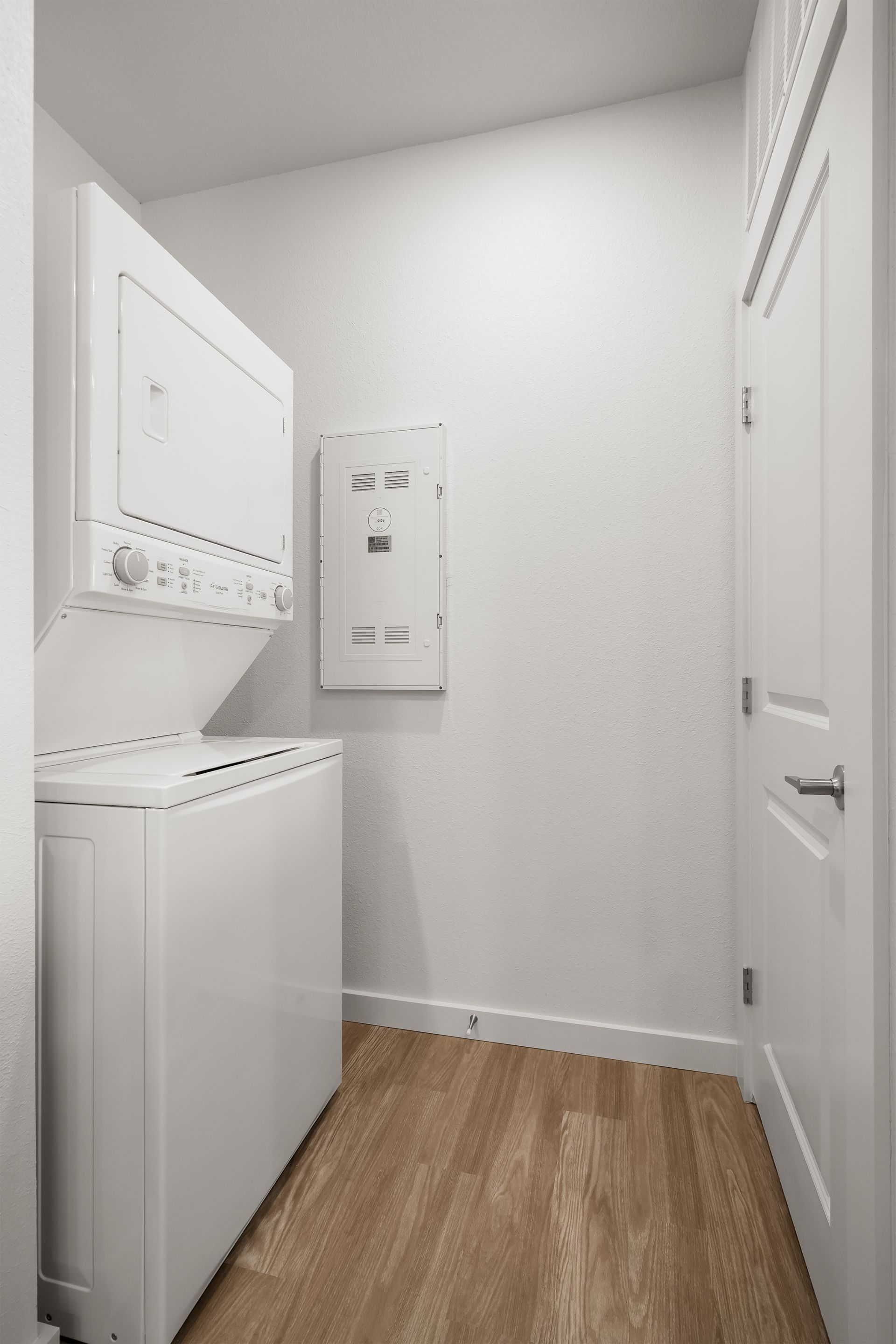 A laundry room with a washer and dryer stacked on top of each other.