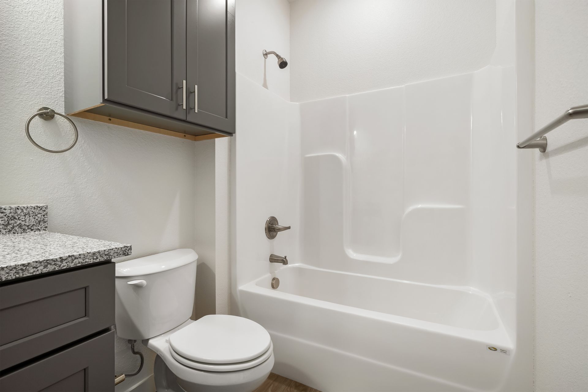 A bathroom with a toilet , sink , bathtub and shower.