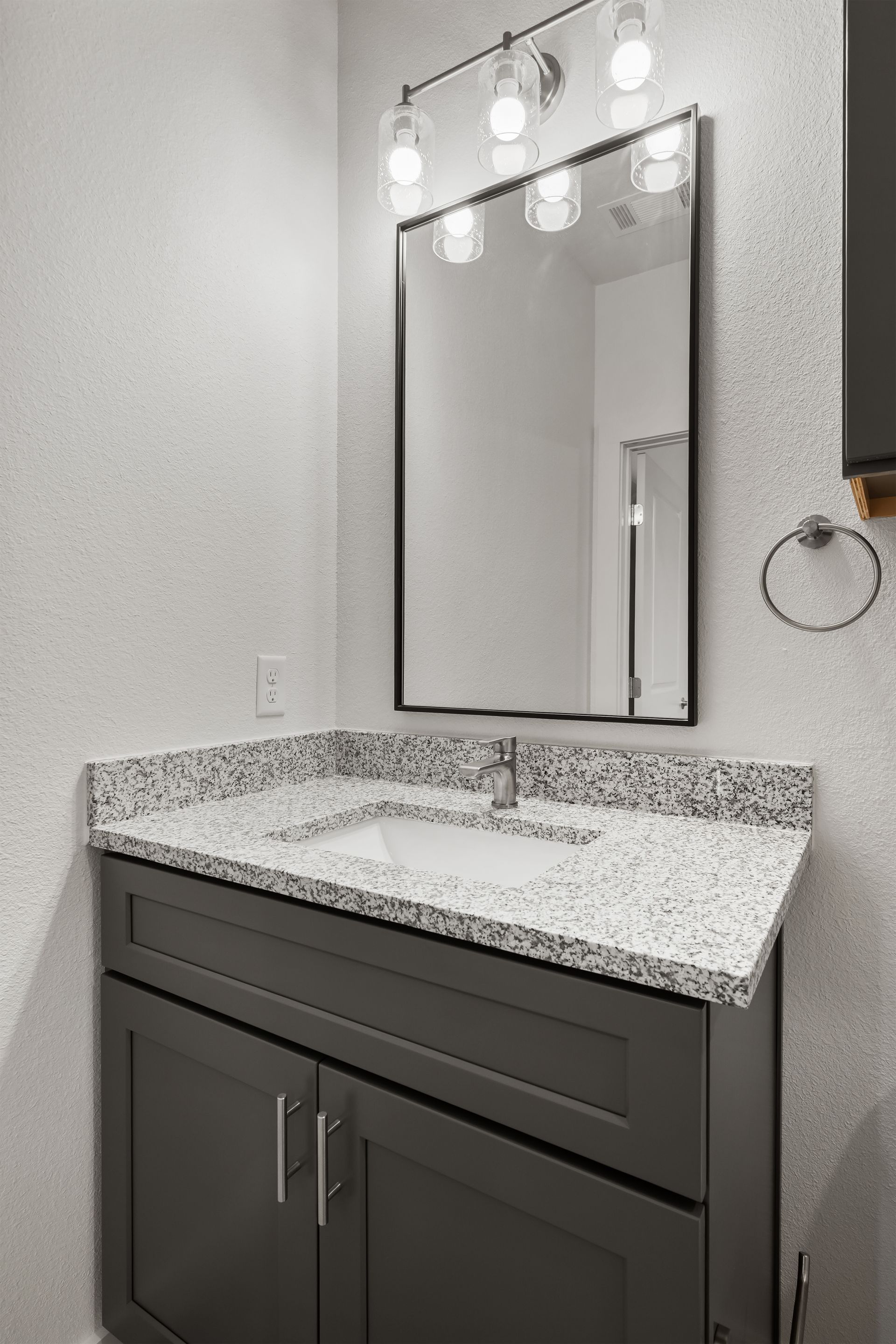 A bathroom with a sink , mirror and cabinets.