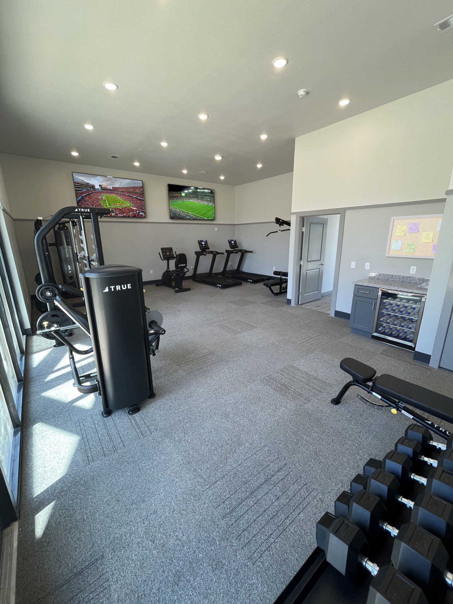 A large gym with a lot of equipment and a lot of windows.