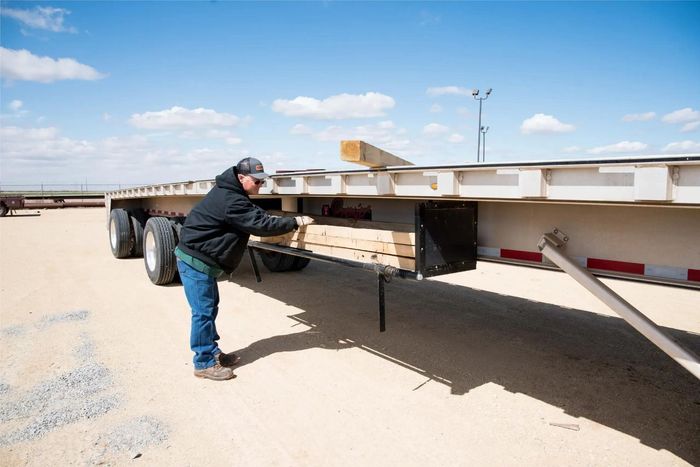 photo of man by flatbed trailer inspecting dunnage rack