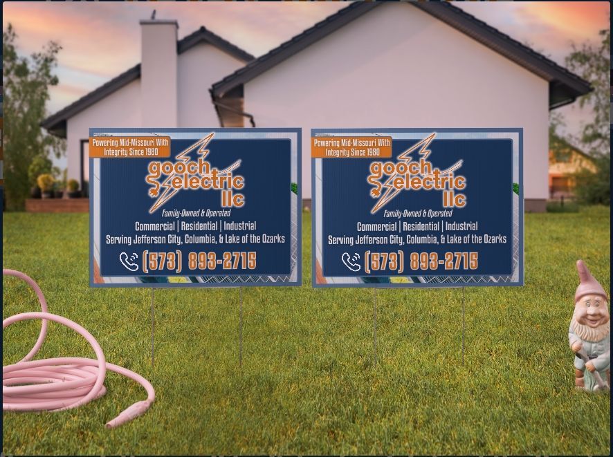 Two identical yard signs for Gouth Electric LLC in front of a house, featuring the company phone number and services.