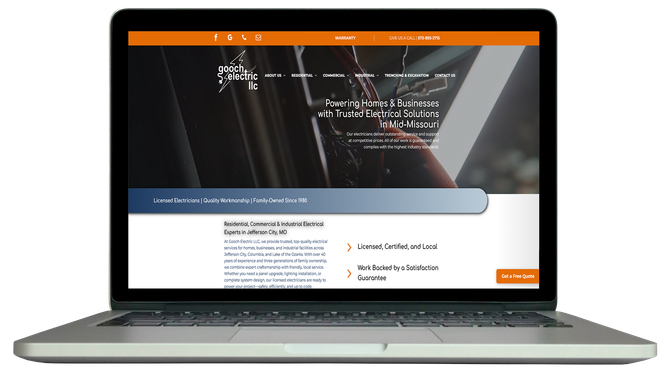 A silver laptop displaying a professional website with an orange header, dark navigation bar, and text.