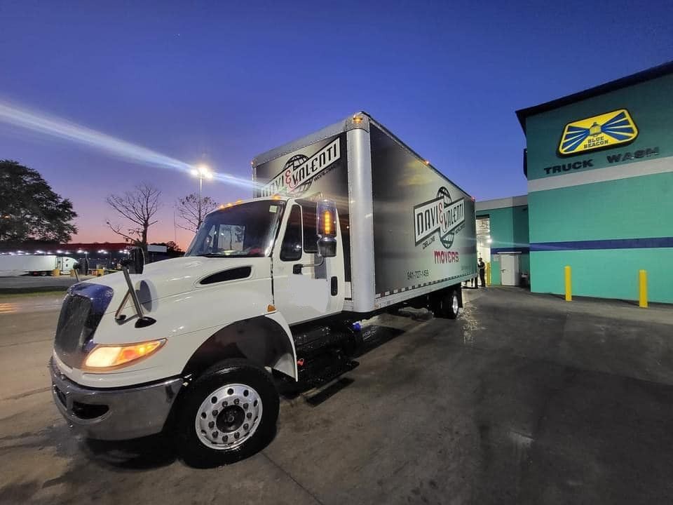 White box truck at a truck wash at dusk. 