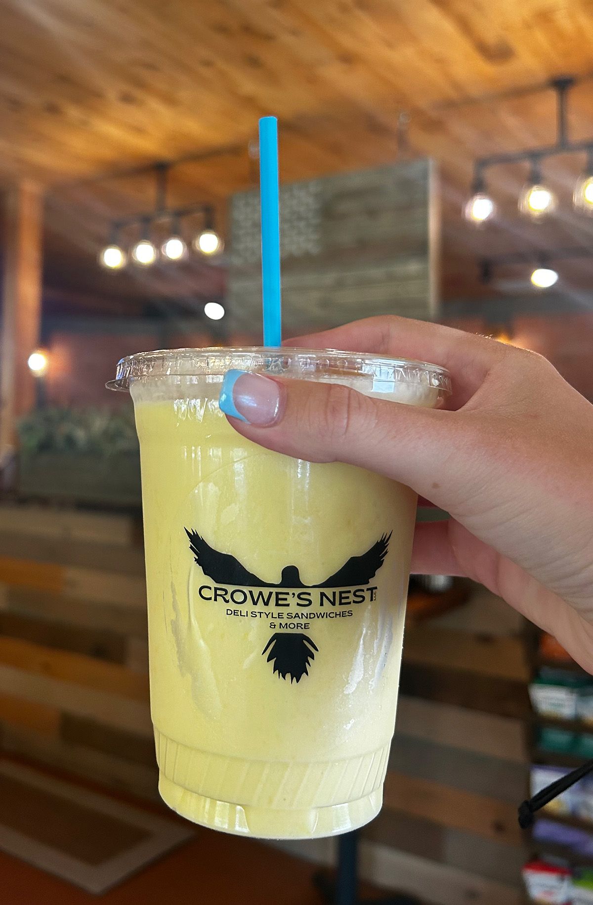A restaurant with tables and chairs and a wooden ceiling.