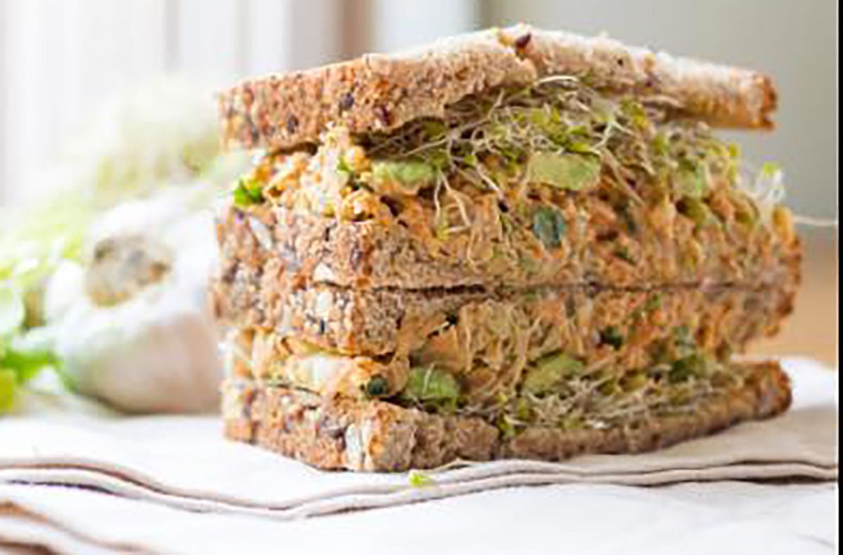 A sandwich is stacked on top of each other on a napkin on a table.