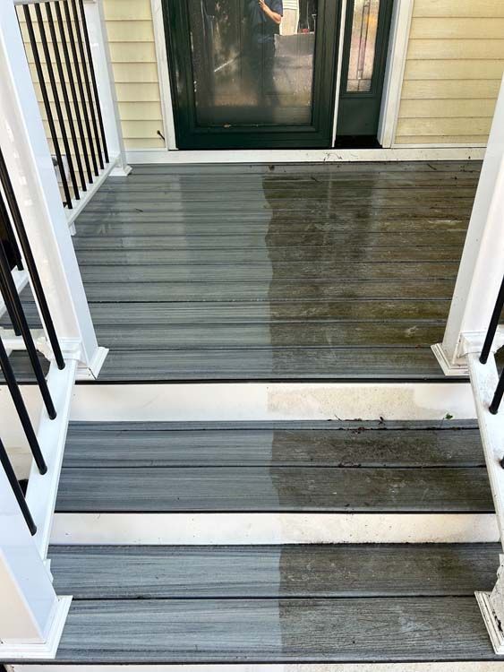 Half of a wooden porch and steps cleaned