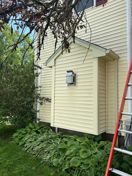 Yellow-sided house with a small shed-like structure