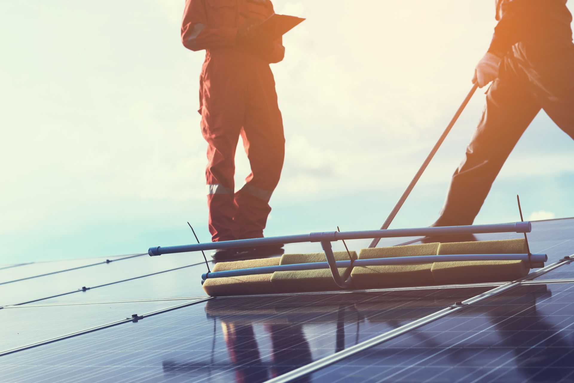 Two workers cleaning solar panels 