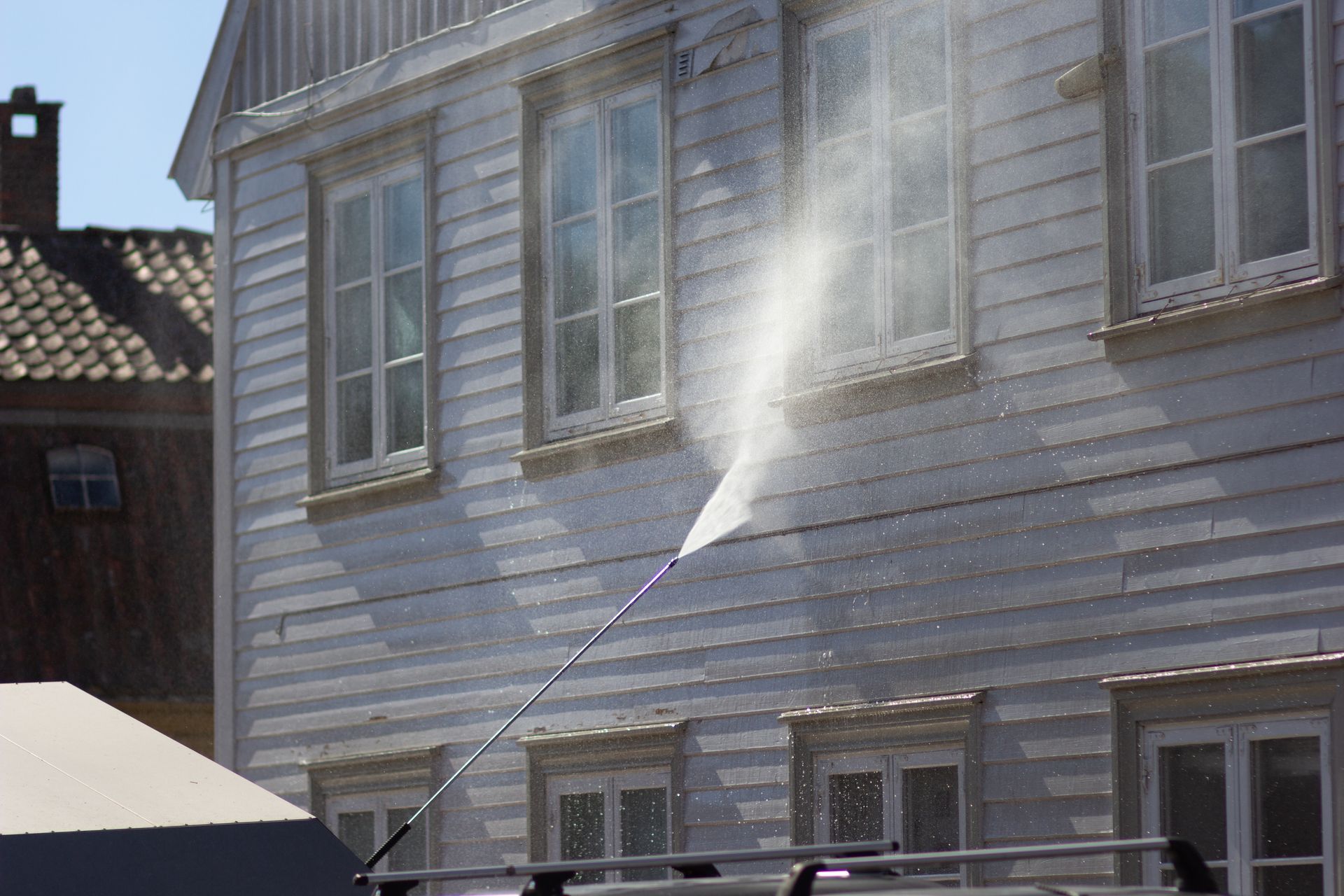 Power washing a white wooden building