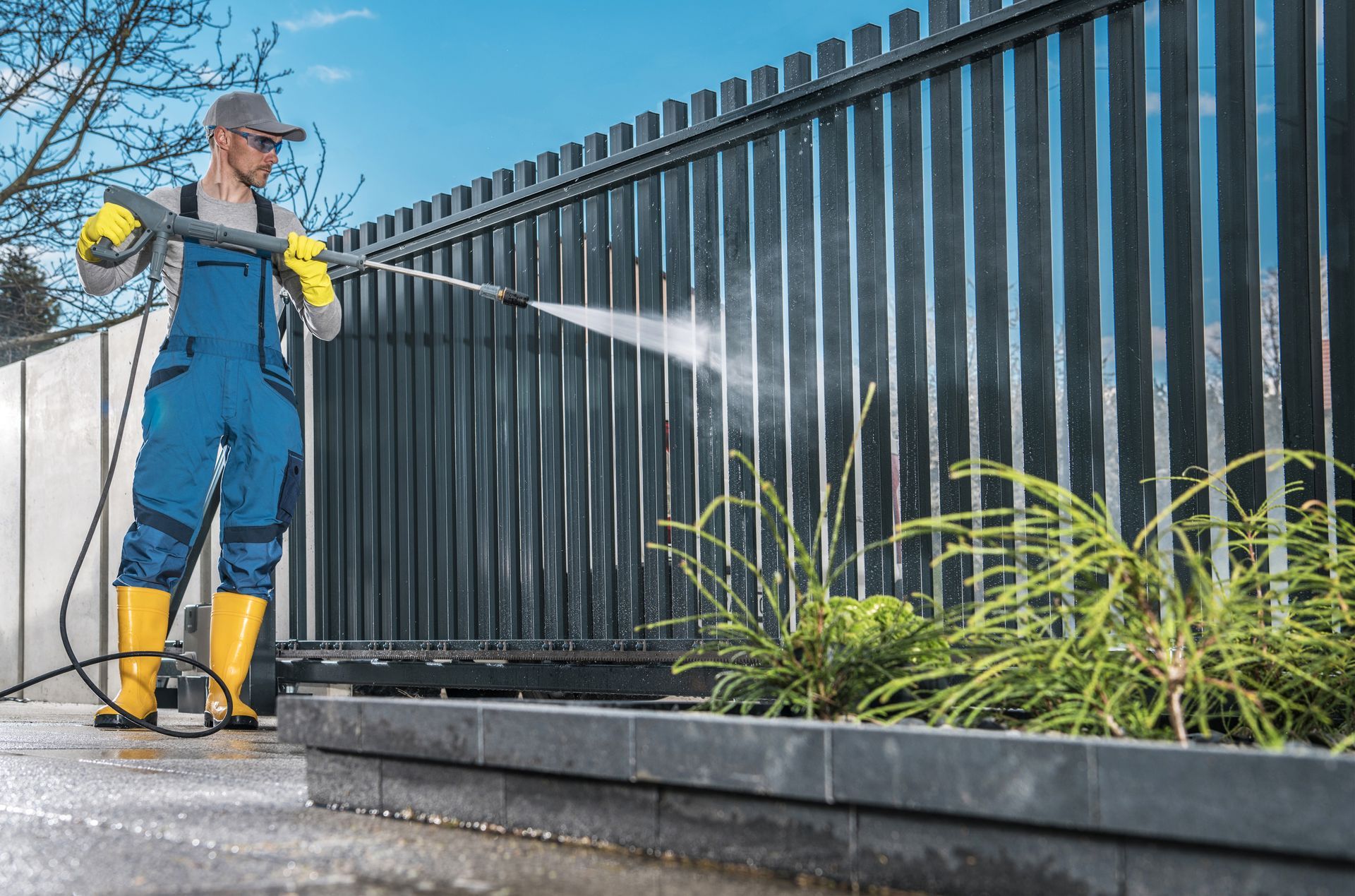 A person spraying a window with a pressure washer