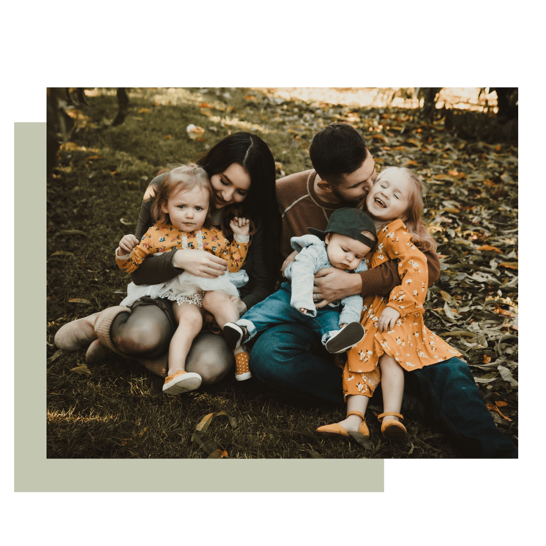 A family is sitting on the grass with their children. Family photographer near me