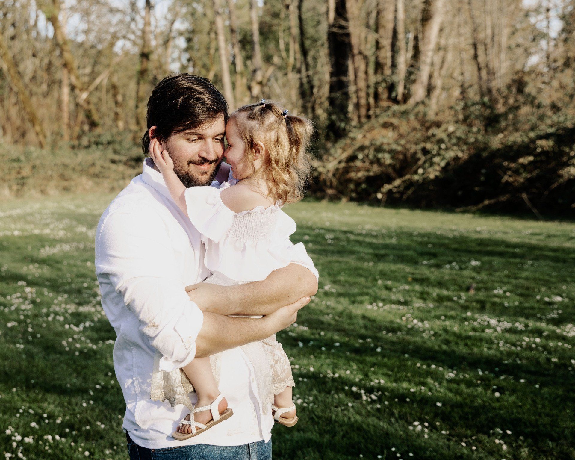 A man is holding a little girl in his arms.