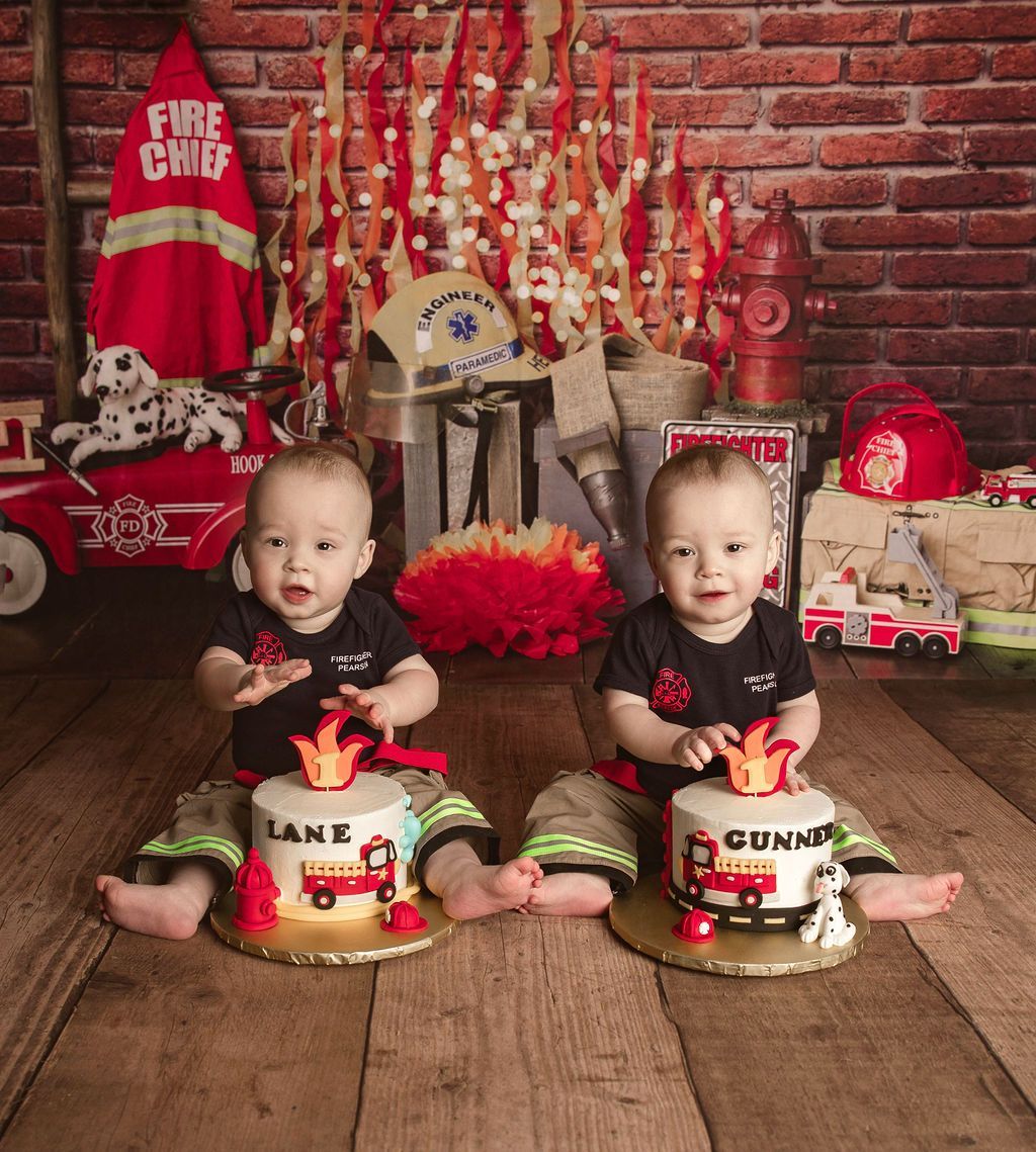 Two babies are sitting on a wooden floor with fire cakes