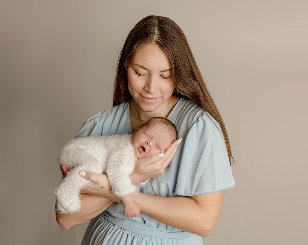 A woman is holding a newborn baby in her arms.