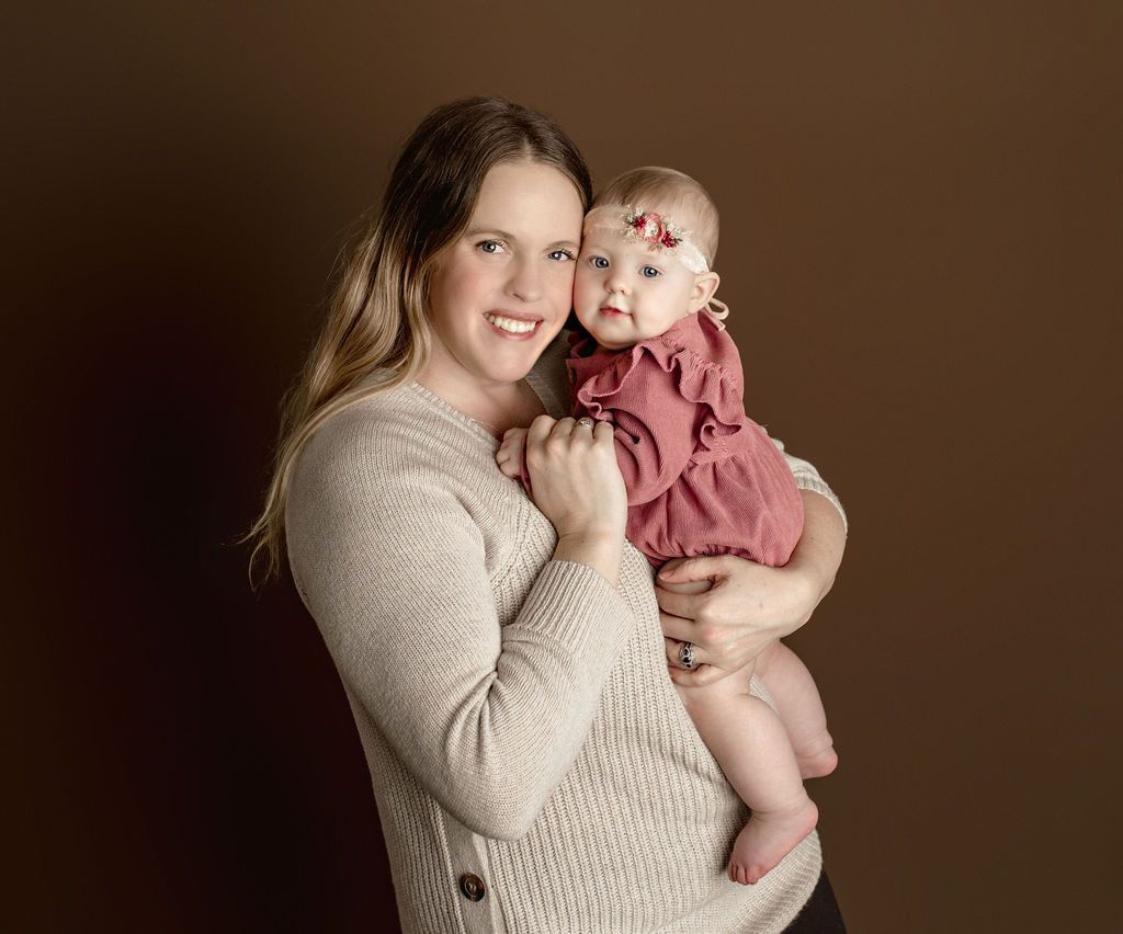 A woman is holding a baby girl in her arms.
