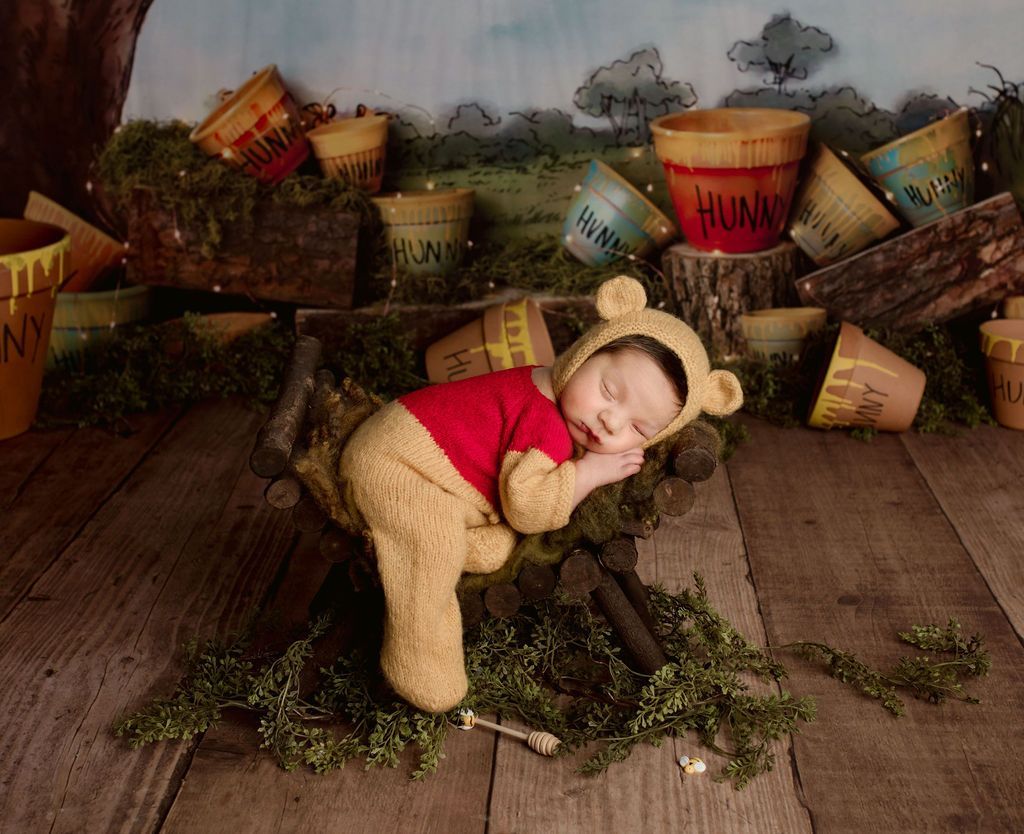 A baby is sleeping in a winnie the pooh costume, fun baby props, newborn props