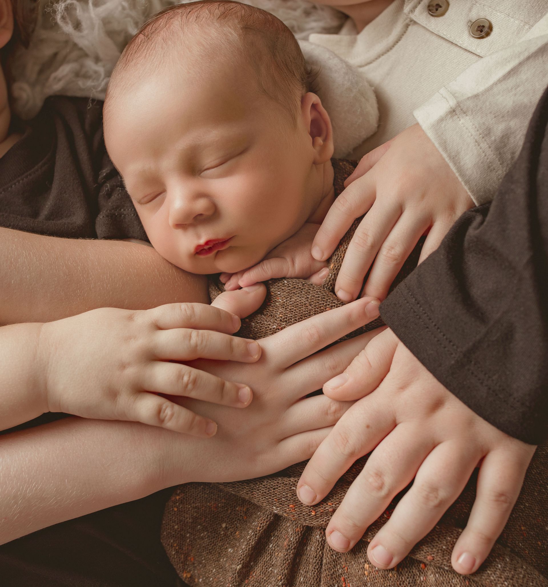 A newborn baby is sleeping in a wicker basket.