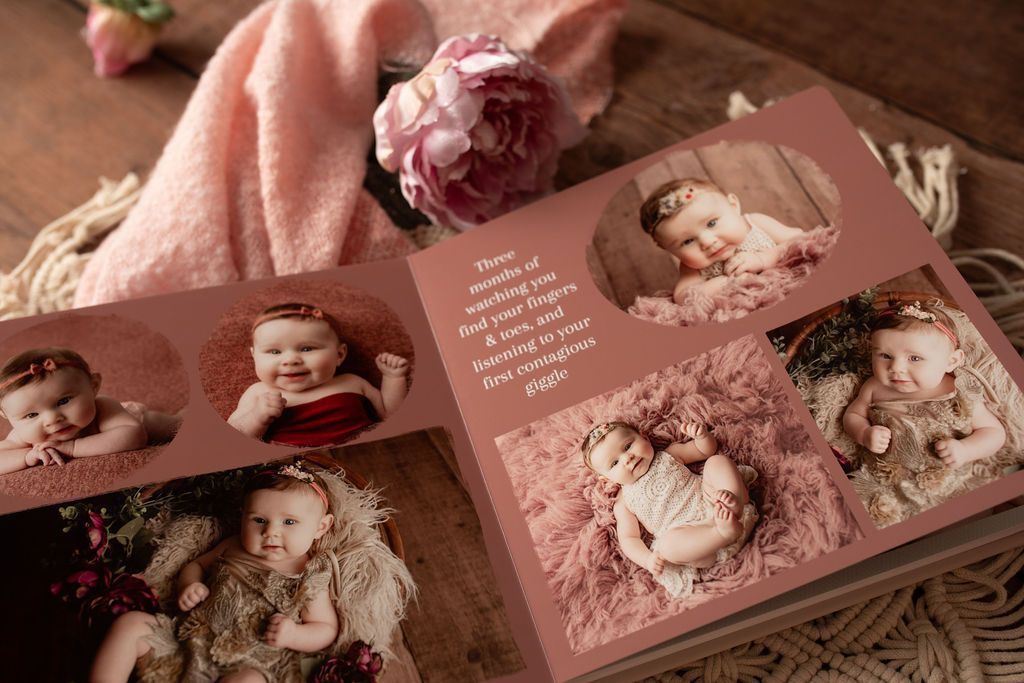 A baby is laying on a pink blanket on a wooden table.