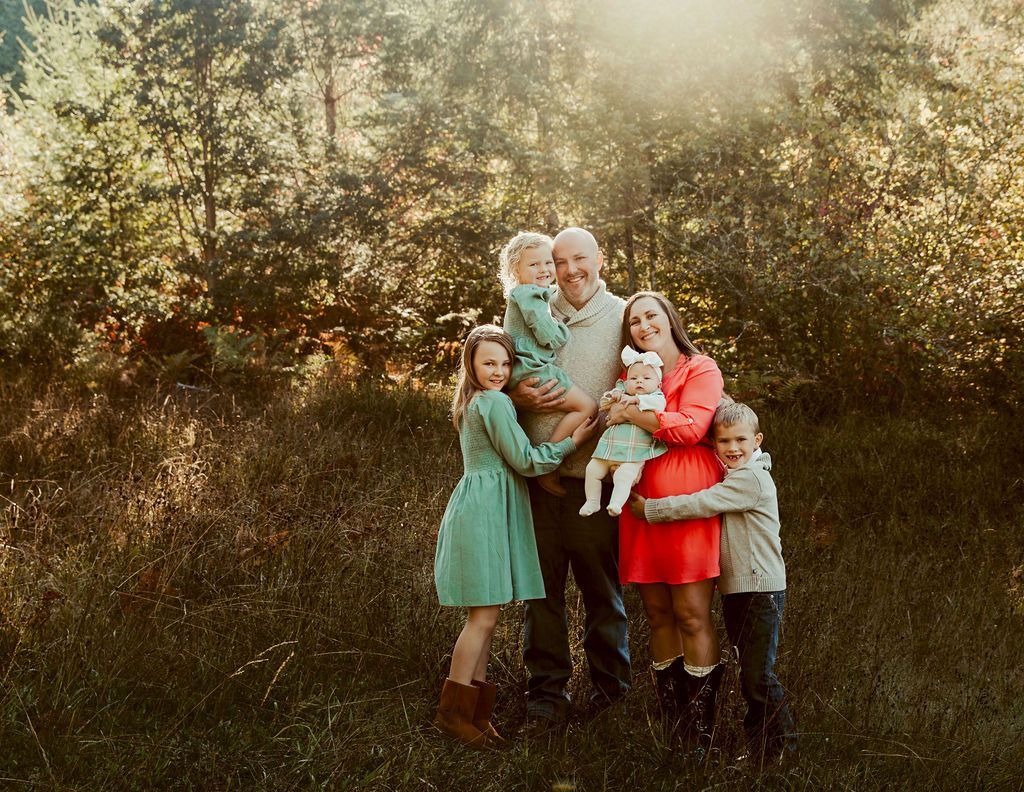 A family is posing for a picture in a field.