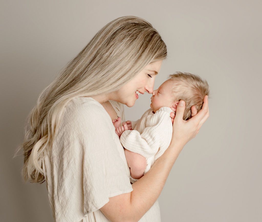 A woman is holding a newborn baby in her arms.
