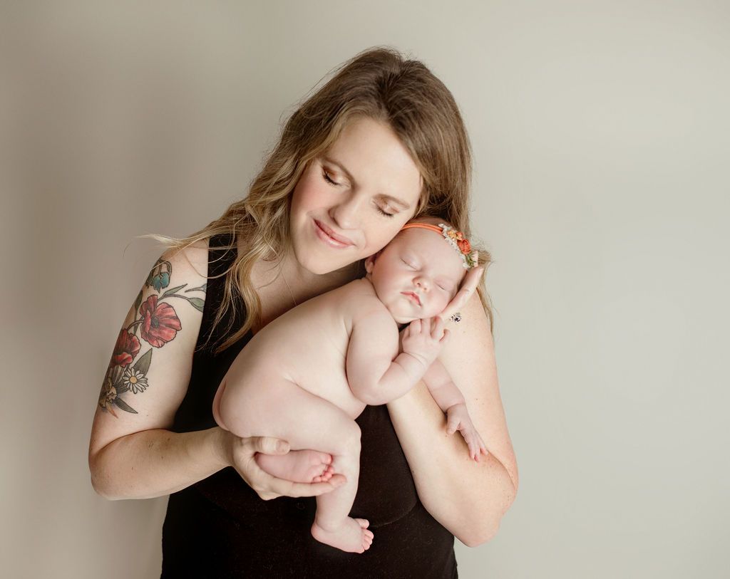 A woman is holding a newborn baby in her arms.