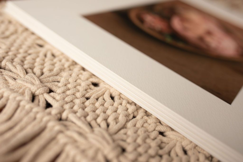 A picture of a baby is sitting on top of a knitted blanket.
