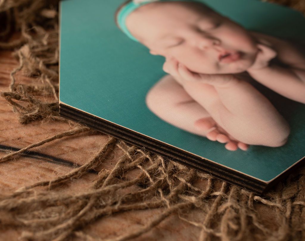 A picture of a baby sleeping on a wooden table.